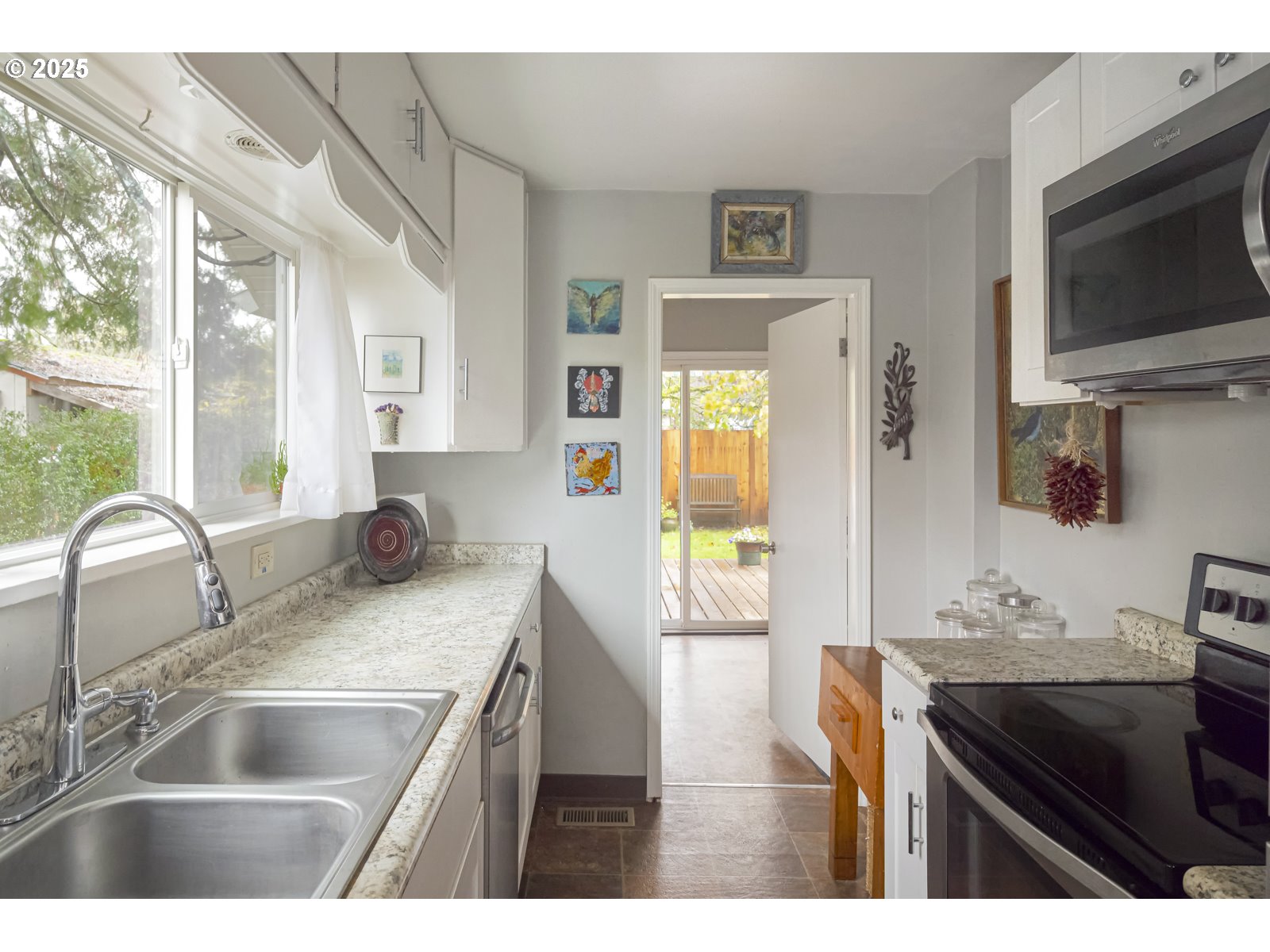 6125 Southeast 138th Place Portland, OR 97236 - Photo 14 of 32 a kitchen with granite countertop a sink and a stove top oven with wooden floor