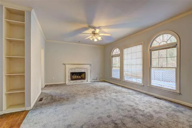 an empty room with windows and fireplace