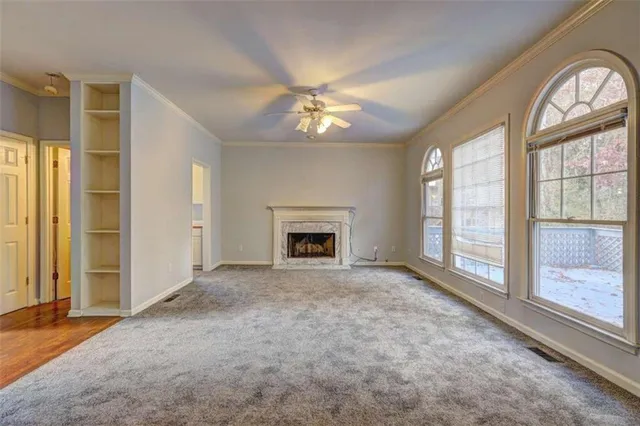 an empty room with windows and fireplace