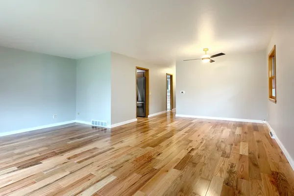 a view of a livingroom with wooden floor and a ceiling fan