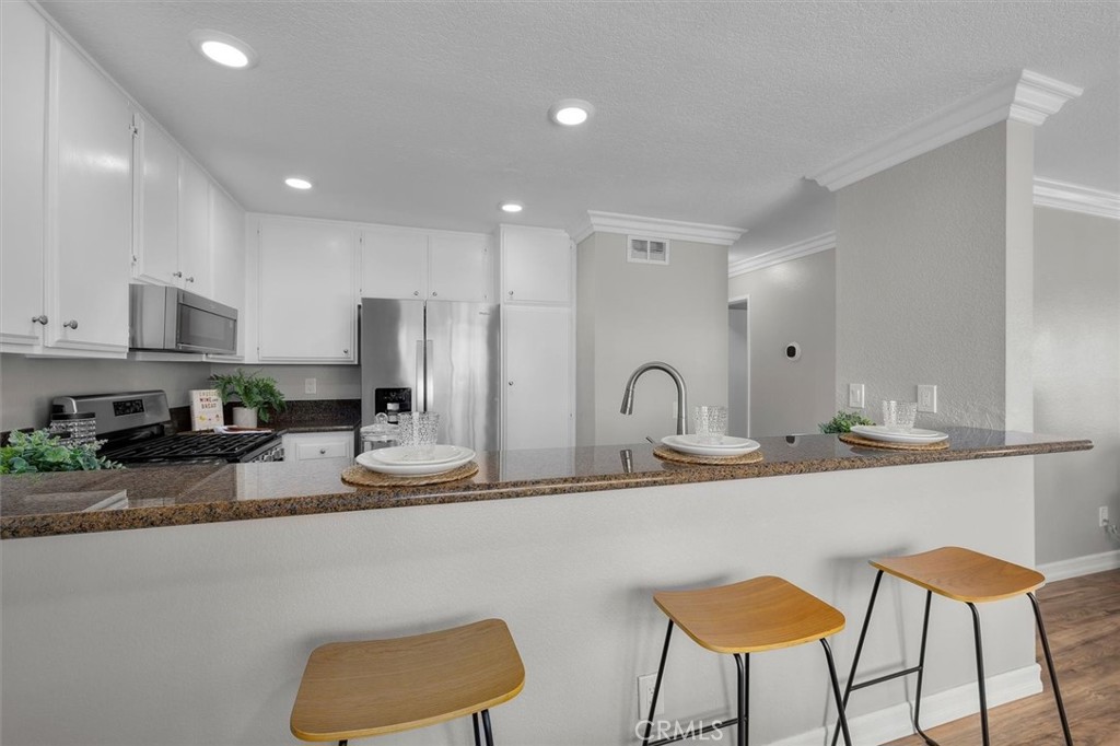 22206 Rim Pointe, Unit 7G Lake Forest, CA 92630 - Photo 15 of 39 a kitchen with stainless steel appliances granite countertop a sink and a refrigerator