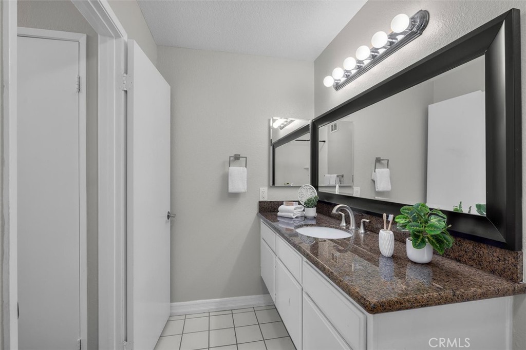 22206 Rim Pointe, Unit 7G Lake Forest, CA 92630 - Photo 30 of 39 a bathroom with sinks granite countertop a sink and a mirror