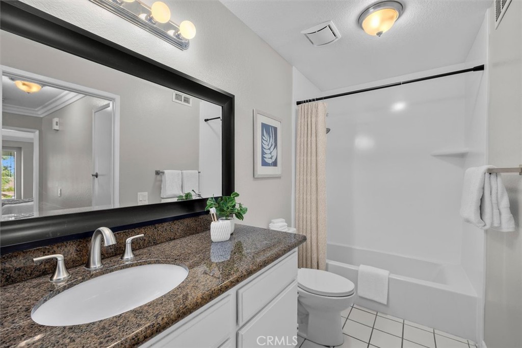 22206 Rim Pointe, Unit 7G Lake Forest, CA 92630 - Photo 32 of 39 a bathroom with a granite countertop sink toilet and shower