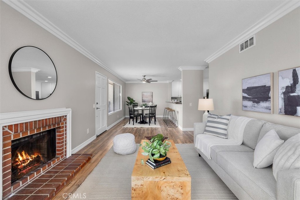 22206 Rim Pointe, Unit 7G Lake Forest, CA 92630 - Photo 9 of 39 a living room with furniture a fireplace a rug and a window
