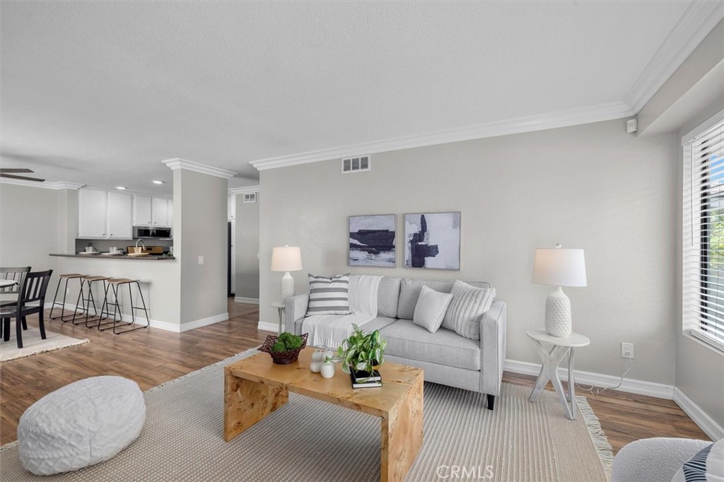 22206 Rim Pointe, Unit 7G Lake Forest, CA 92630 - Photo 10 of 39 a living room with furniture and a dining table with wooden floor