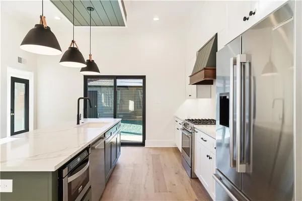 a kitchen with stainless steel appliances a stove refrigerator and cabinets