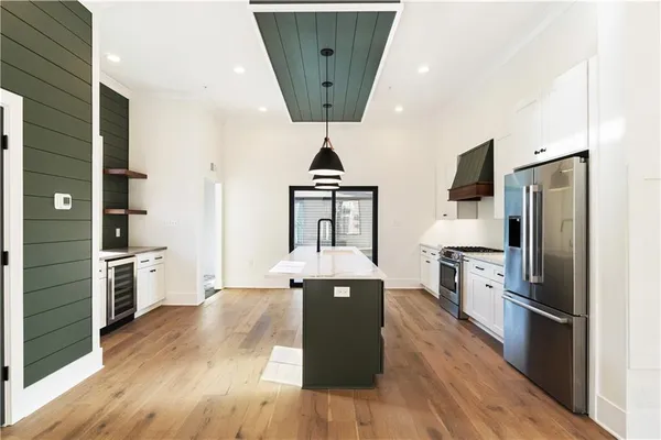 a kitchen with granite countertop a refrigerator a stove top oven and cabinets