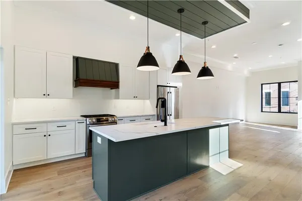 a kitchen with stainless steel appliances granite countertop a sink a stove and a wooden floors