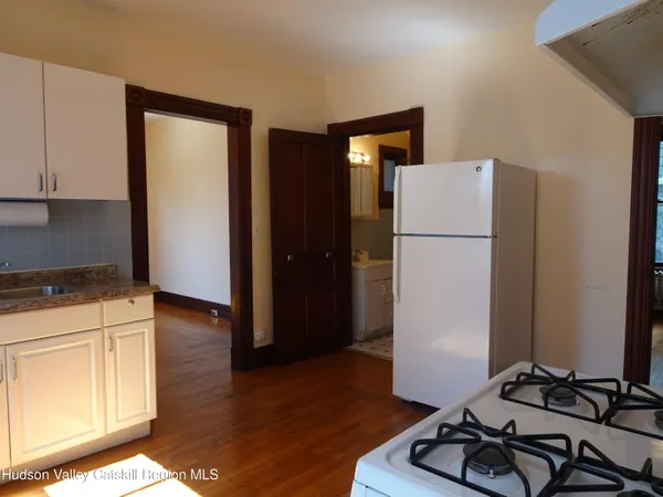 a view of a kitchen with wooden floor and electronic appliances