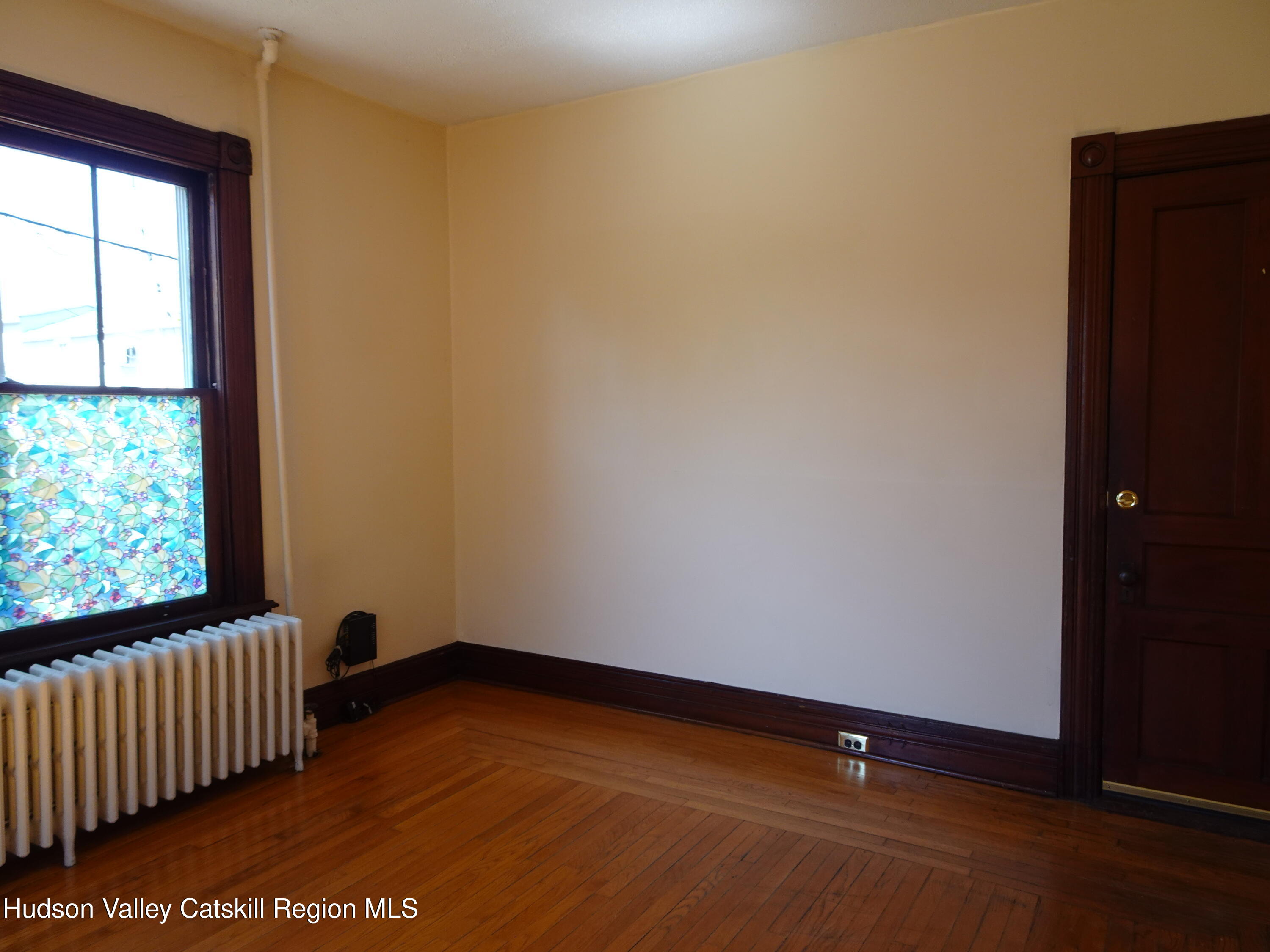 32-34 8th Street, Unit 1 Hudson, NY 12534 - Photo 5 of 14 an empty room with wooden floor and windows