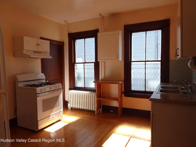 a kitchen with stainless steel appliances granite countertop a stove a sink and a window