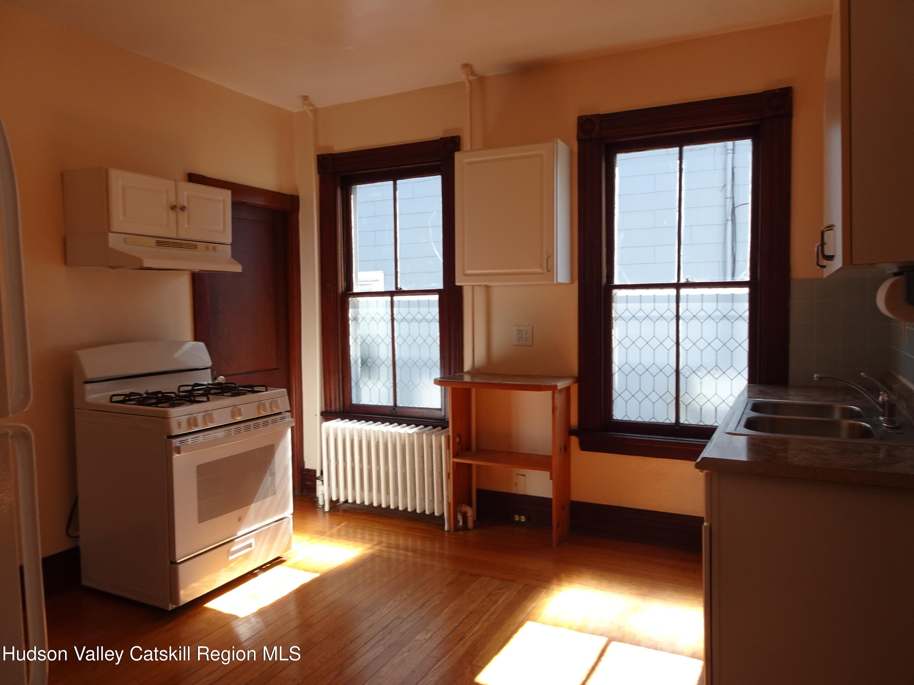 32-34 8th Street, Unit 1 Hudson, NY 12534 - Photo 10 of 14 a kitchen with stainless steel appliances granite countertop a stove a sink and a window