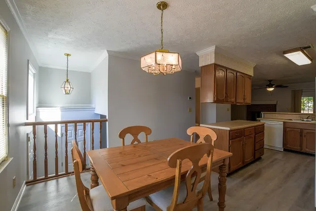 a dining room with furniture a chandelier and wooden floor