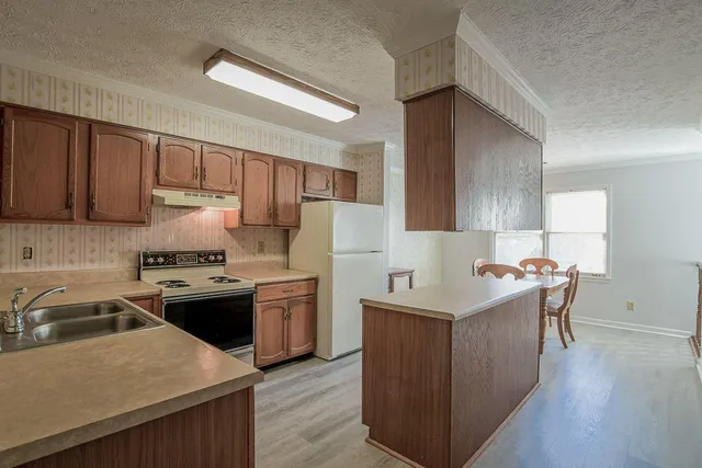 a kitchen with stainless steel appliances granite countertop a sink stove and refrigerator