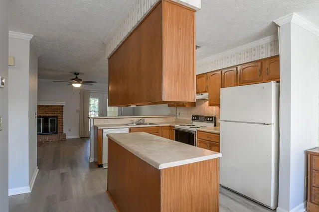 a kitchen with a stove a refrigerator and a fireplace