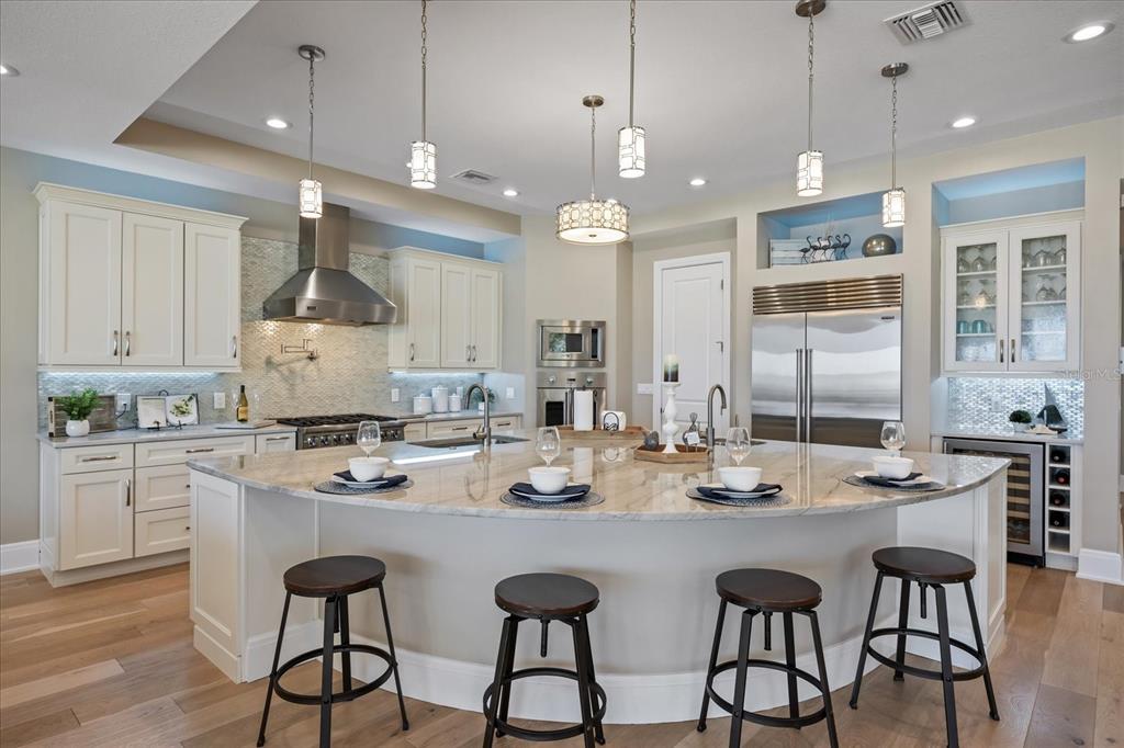 2 Gulf Boulevard Indian Rocks Beach, FL 33785 - Photo 16 of 79 a kitchen with stainless steel appliances kitchen island granite countertop a dining table chairs and white cabinets
