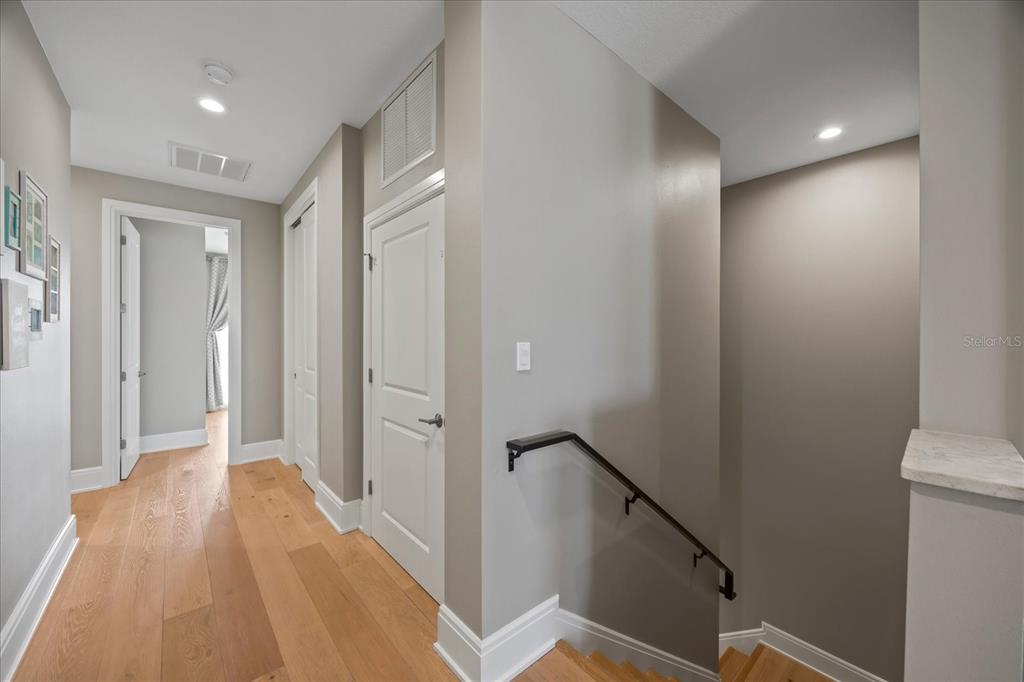 2 Gulf Boulevard Indian Rocks Beach, FL 33785 - Photo 42 of 79 a view of a hallway with wooden floor and staircase