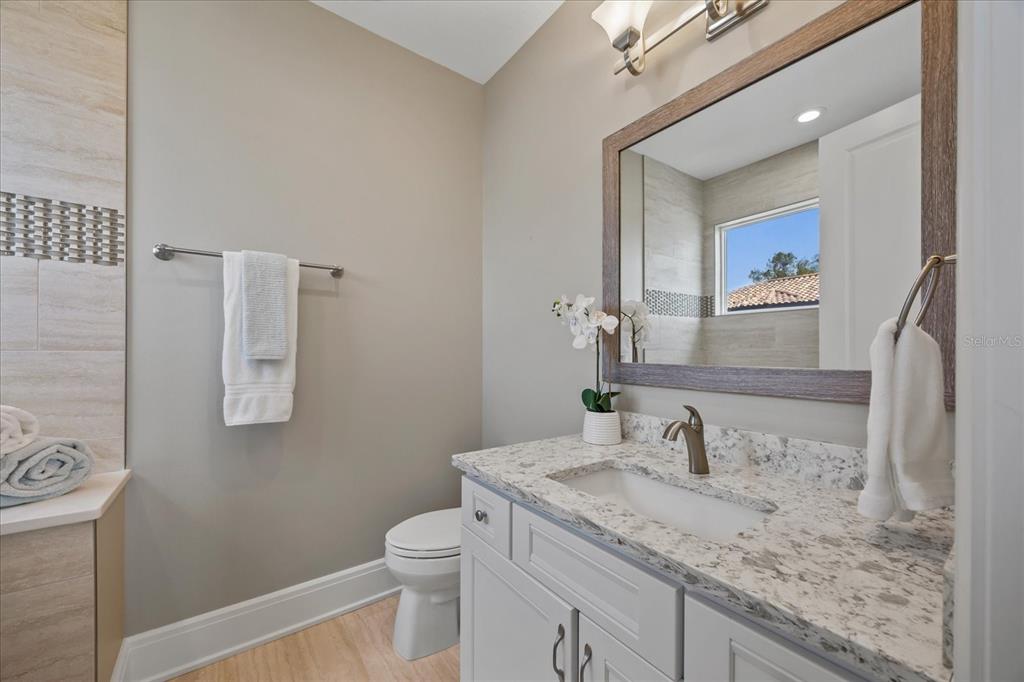 2 Gulf Boulevard Indian Rocks Beach, FL 33785 - Photo 65 of 79 a bathroom with a granite countertop sink toilet and mirror