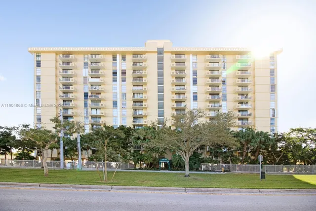a view of a tall building next to a yard