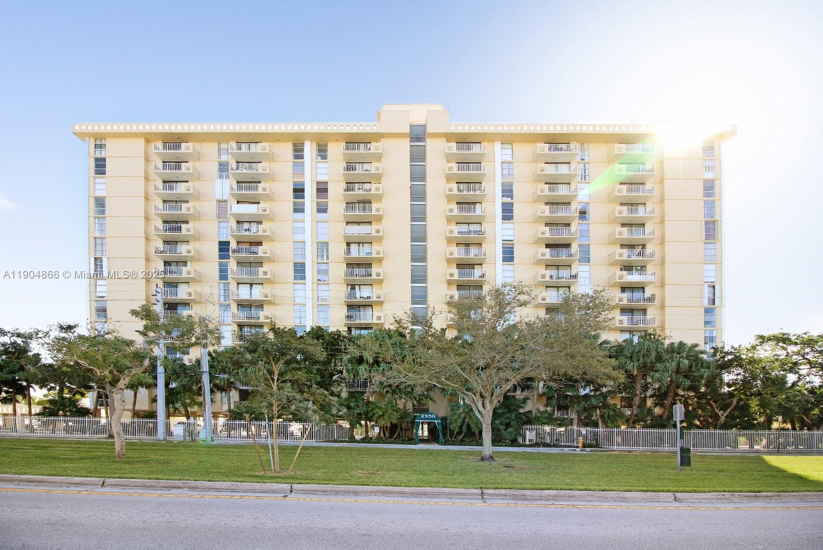 a view of a tall building next to a yard