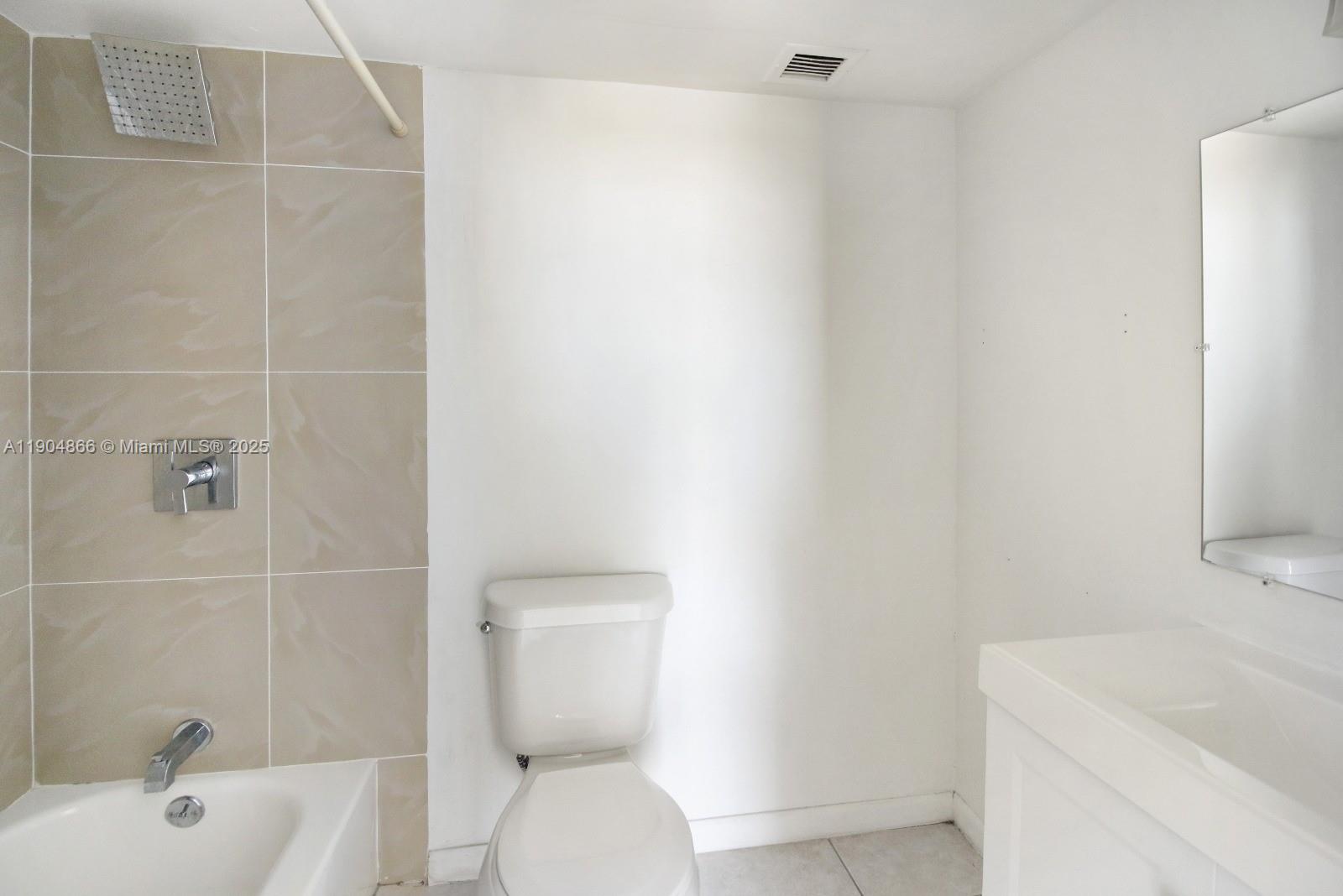 2350 Northeast 135th Street, Unit 1111 North Miami, FL 33181 - Photo 18 of 21 a white toilet sitting next to a white bath tub