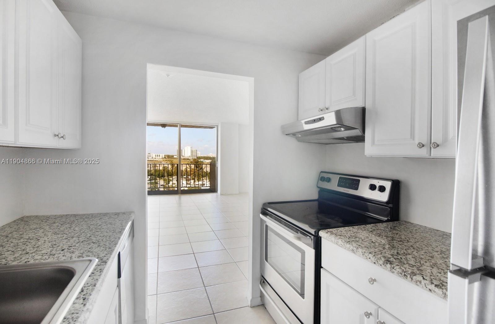 2350 Northeast 135th Street, Unit 1111 North Miami, FL 33181 - Photo 2 of 21 a kitchen with stainless steel appliances granite countertop a stove a microwave and a sink