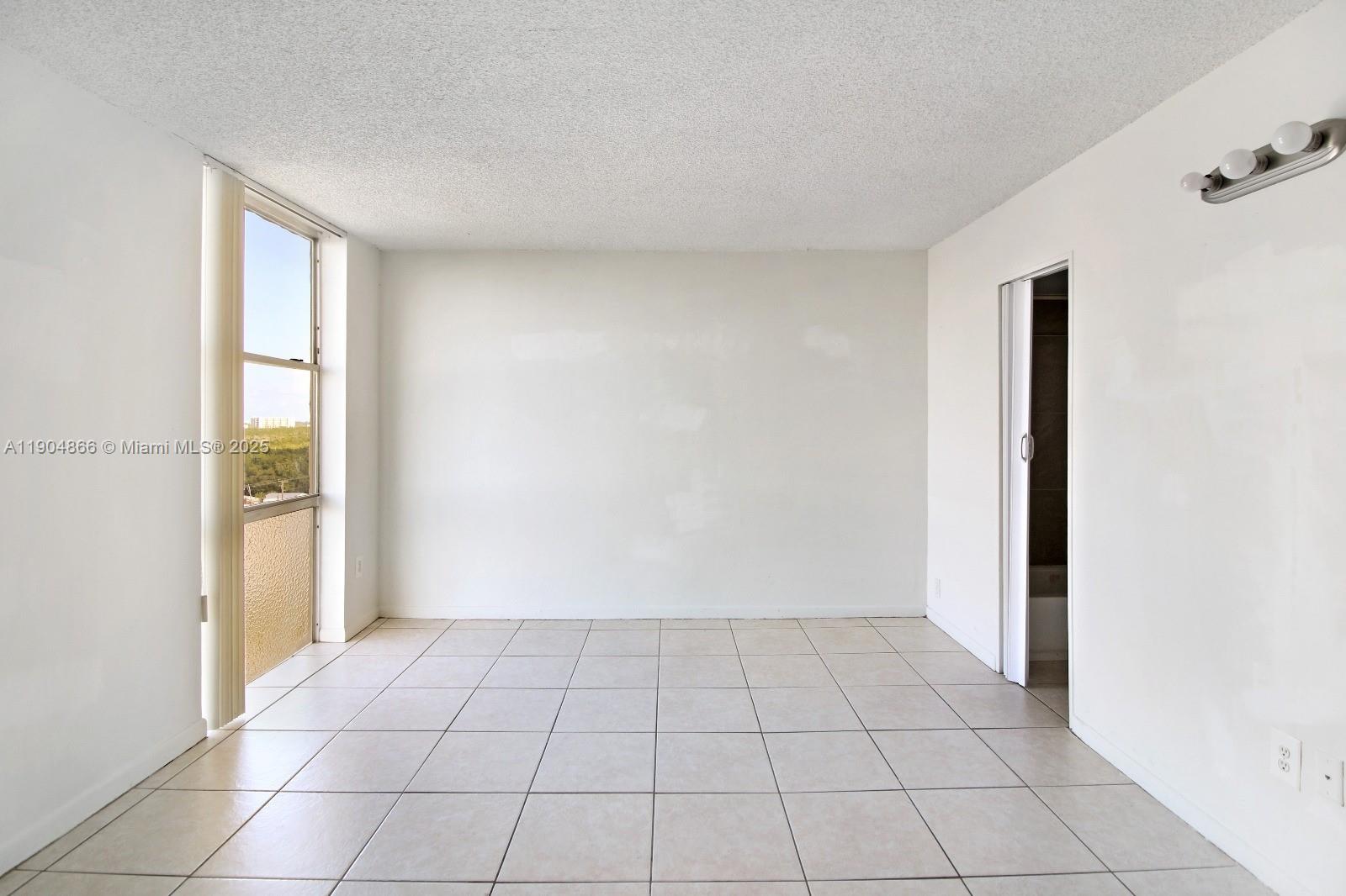 2350 Northeast 135th Street, Unit 1111 North Miami, FL 33181 - Photo 21 of 21 a view of an empty room and window