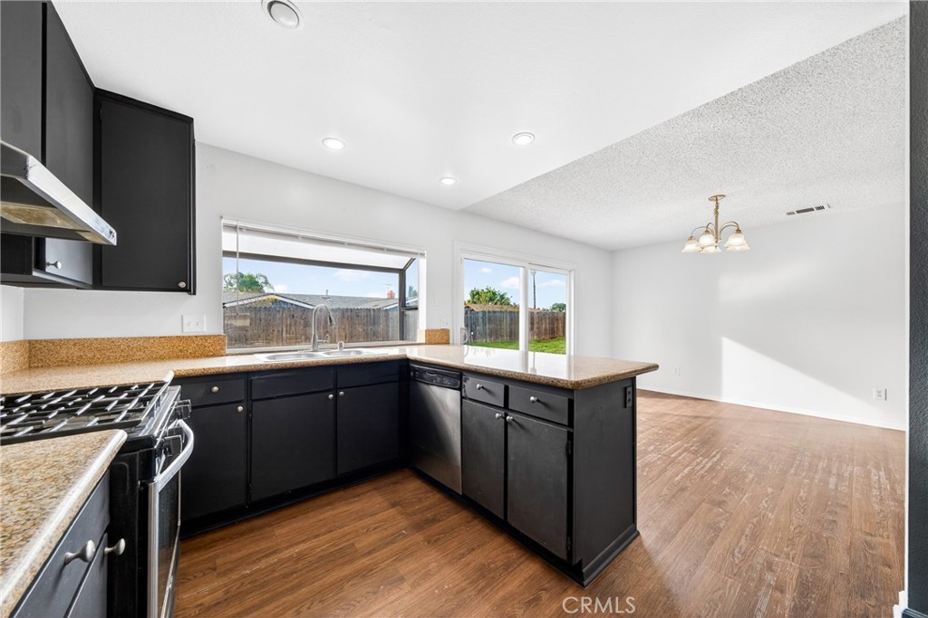 24867 Bower Street Moreno Valley, CA 92553 - Photo 24 of 46 a kitchen with wooden cabinets sink and stove