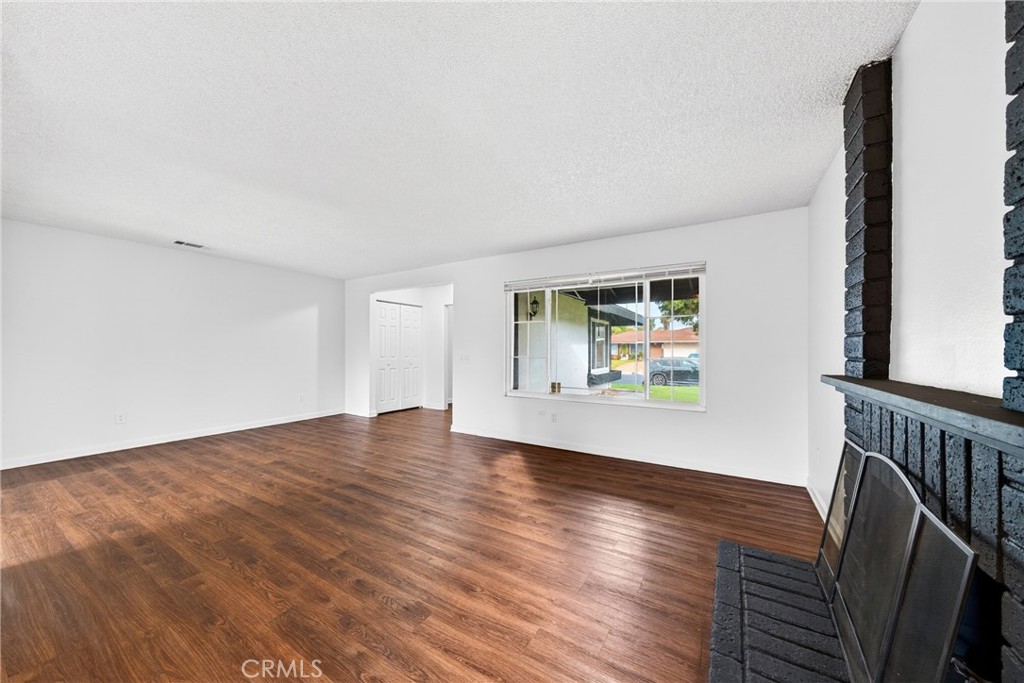 24867 Bower Street Moreno Valley, CA 92553 - Photo 6 of 46 a view of an empty room with wooden floor and a window