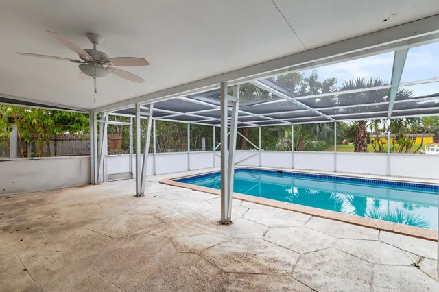 a view of an empty room with a floor to ceiling window and a ceiling fan