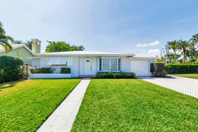 a view of a house with a yard and potted plants