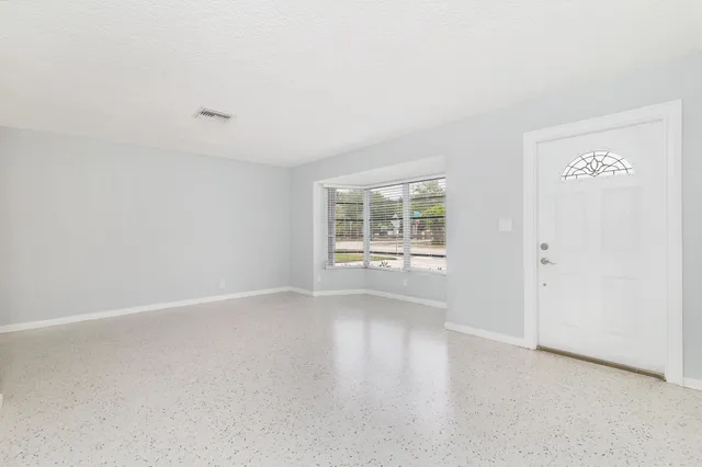 an empty room with windows and closet