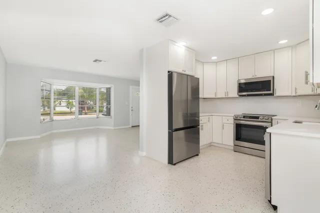 a kitchen with kitchen island a refrigerator stove and microwave