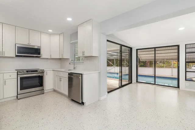 a kitchen with stainless steel appliances a stove sink and microwave