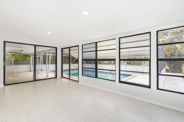 an empty room with sliding glass door and windows