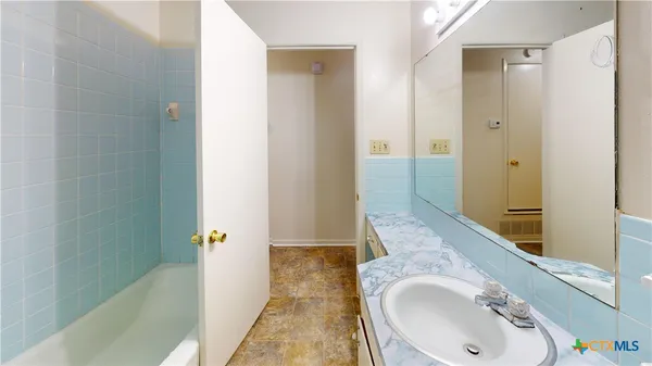 a bathroom with a granite countertop sink and shower