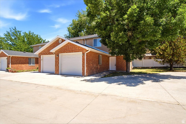 449 West 200 North, Unit 3 Bountiful, UT 84010 - Photo 1 of 23 Brick exterior facade with white garage doors and a light-colored main entry door