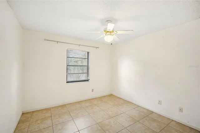 an empty room with fan and windows