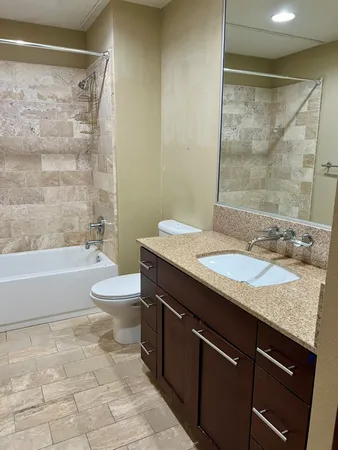 a bathroom with a granite countertop sink toilet and shower