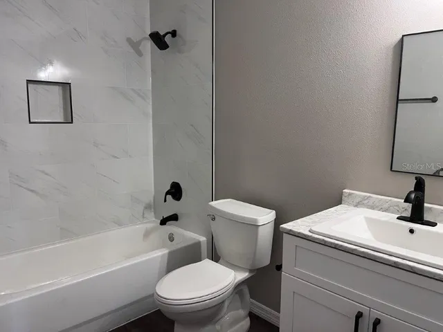 a white toilet sitting next to a bath tub