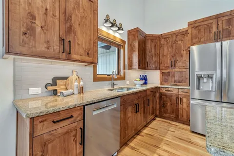 a kitchen with stainless steel appliances granite countertop a sink stove and refrigerator