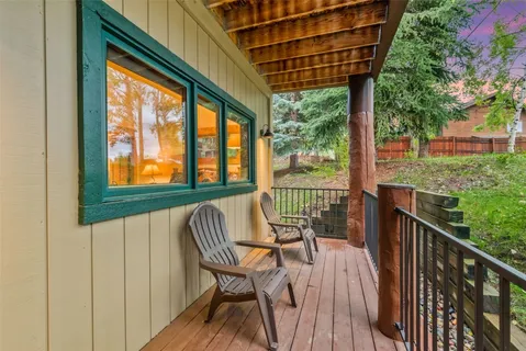 a front view of a house with large windows and a small yard