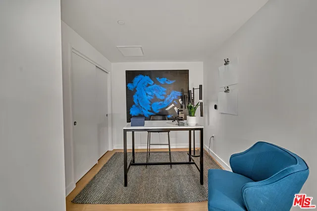 a living room with furniture a rug and a wall painting