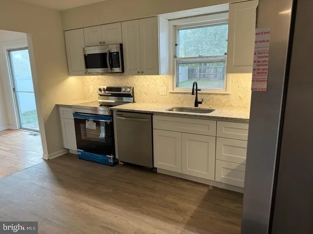 a kitchen with stainless steel appliances granite countertop a sink and a stove top oven