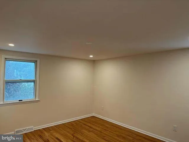 a view of room with window and wooden floor