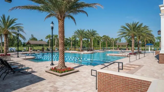 a view of a swimming pool with a patio and a yard
