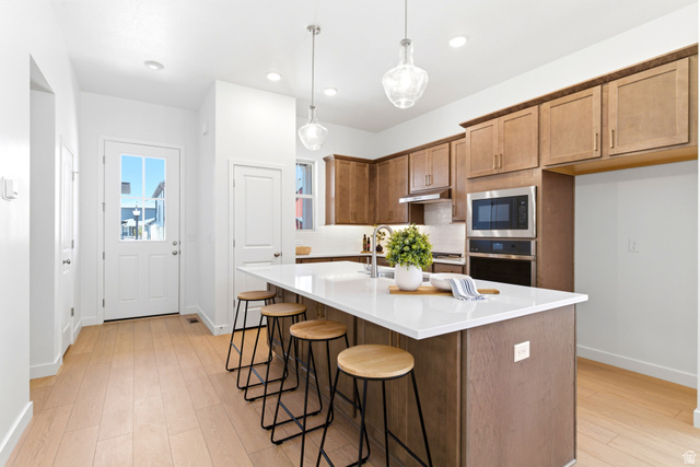 7243 West Terraine Road West Jordan, UT 84081 - Photo 9 of 31 Kitchen showcasing a central island with white countertop, light wood-finish flooring, and recessed lighting