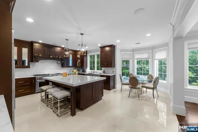 a kitchen with stainless steel appliances a kitchen island a table and chairs in it