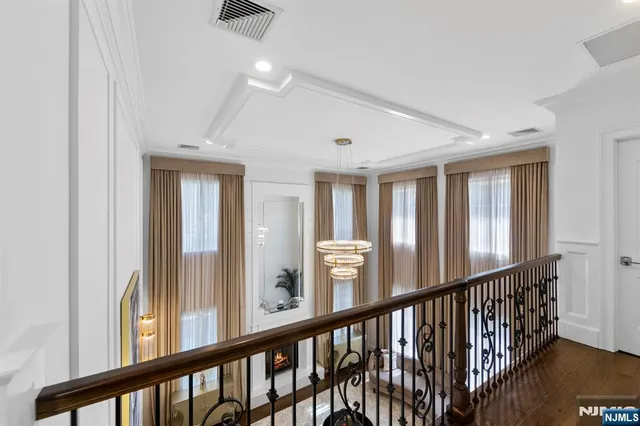 a spacious bedroom with a large bed a flat tv screen and a fireplace with the wooden floor