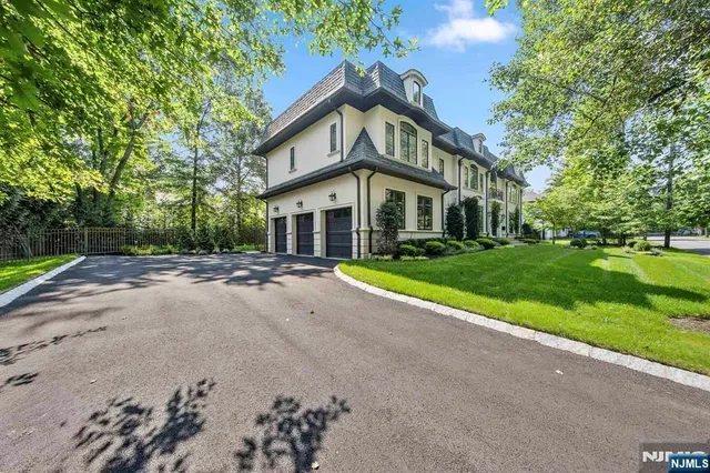 a view of a white house with a big yard and large trees